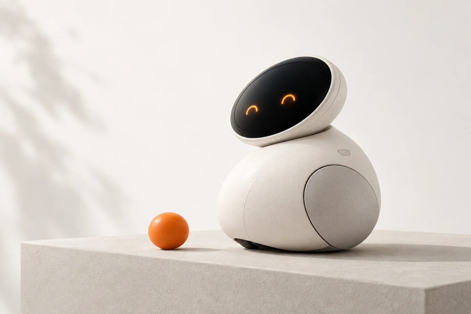 An original little white robot with warm amber eyes, beside an orange ball in a sunlit, minimalist setting.